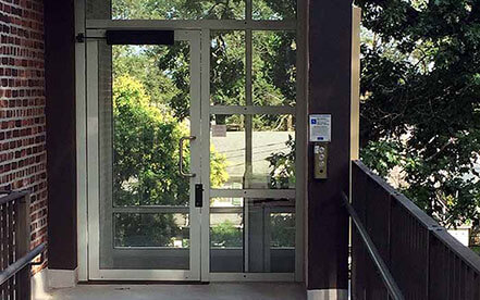 Genesis shaftway model vertical platform lift for wheelchairs with glass doors reflecting the outside