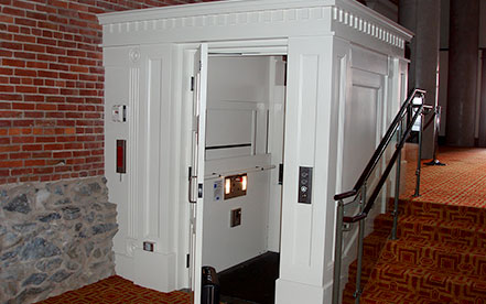 Genesis shaftway model vertical platform lift for wheelchairs built in a white shaftway