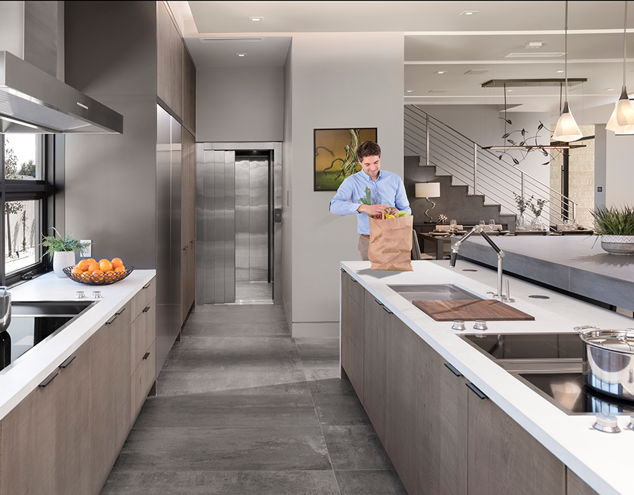 Home elevator with 3 speed doors open halfway in a silver kitchen
