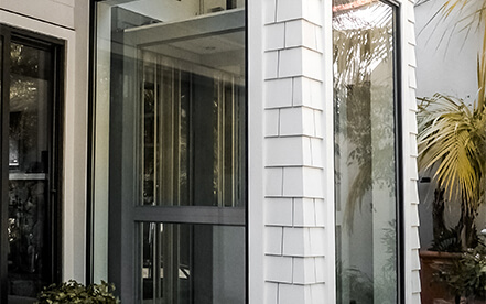 Home elevator with open hall doors showing the cab and fixture