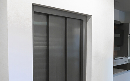 Home elevator light coloured hardwood cab interior with COP