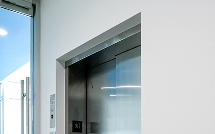 Elvoron LULA elevator application thumbnail showing lift installed near a staircase with exterior glass enclosure – Garaventa Lift