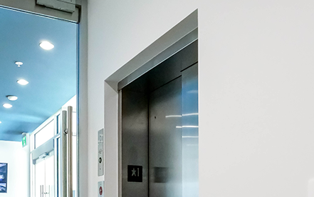 Elvoron LULA elevator application thumbnail showing lift with modern glass enclosure and hallway view – Garaventa Lift