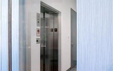Elvoron LULA elevator installed in commercial building – glass doors and accessible hallway entry shown