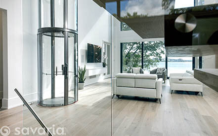 Glass home elevator with red frame installed in a modern residential space
